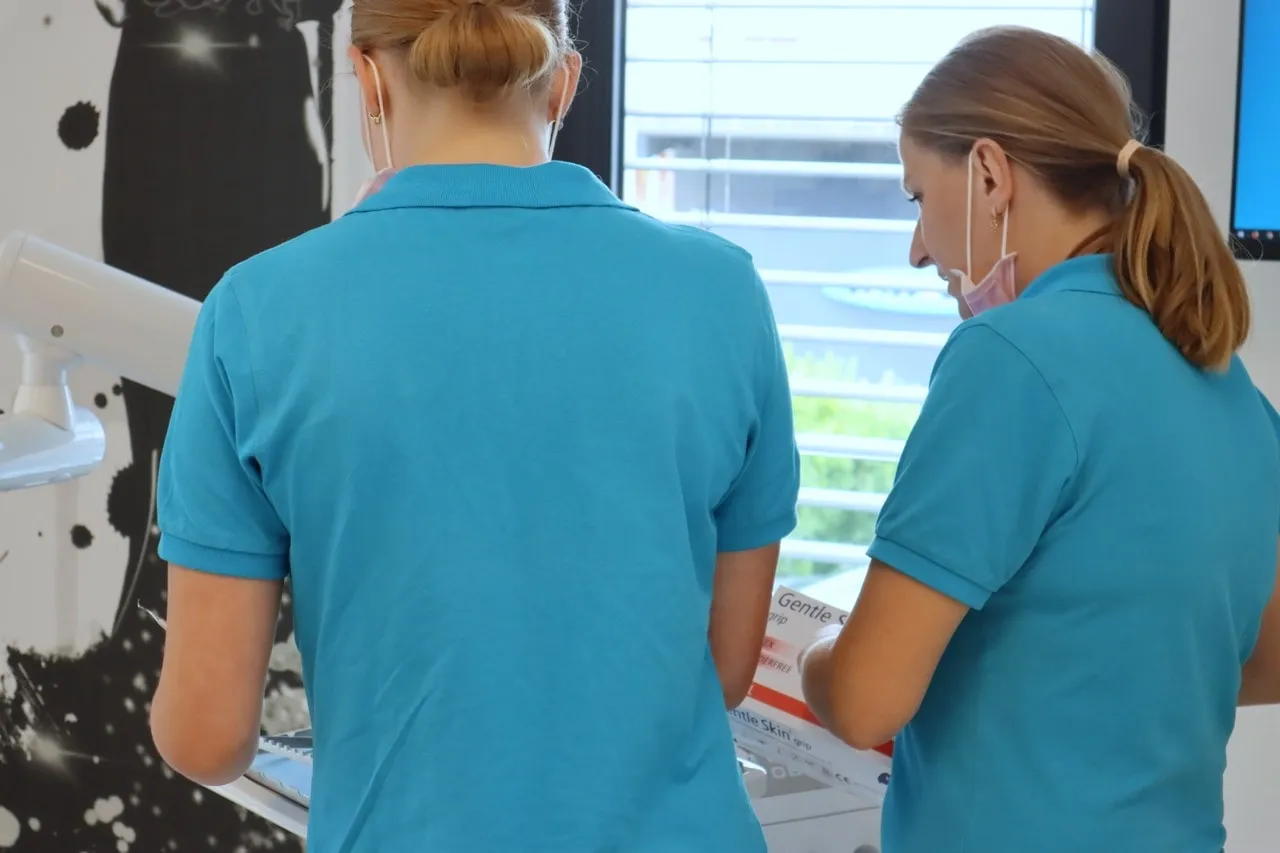 Two dental assistants working hand in hand